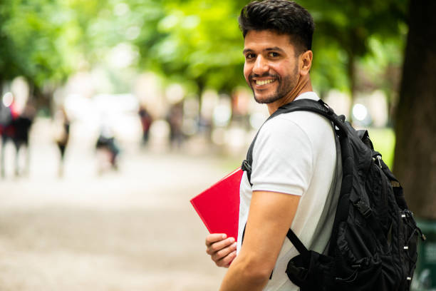 istock Young male student smiling at camera on campus pathway 2184637189