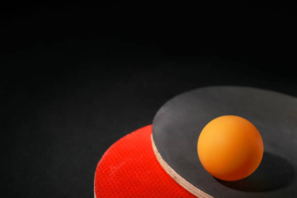 Ping pong ball and rackets on black background, closeup. Space for text