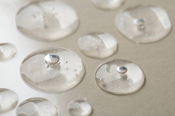istock Drops of cosmetic serum on beige background, macro view 2184641250