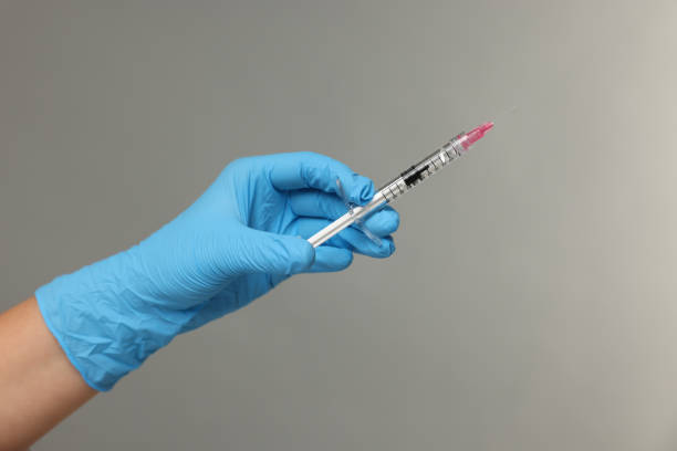 istock Doctor holding syringe on grey background, closeup 2184641255