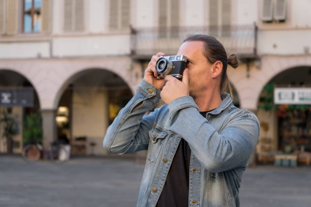 Male Photographer shooting analog film camera in Italian town