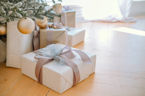 istock Elegant wrapped gifts beneath a Christmas tree in a cozy interior space 2184646827