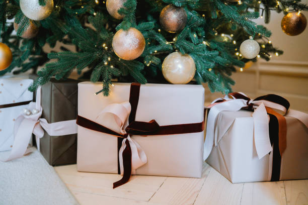 istock Beautifully wrapped gifts beneath a decorated Christmas tree at home 2184646875