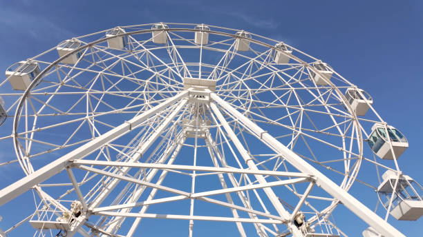 istock A towering white ferris wheel stands tall against a vibrant blue sky 2184647880