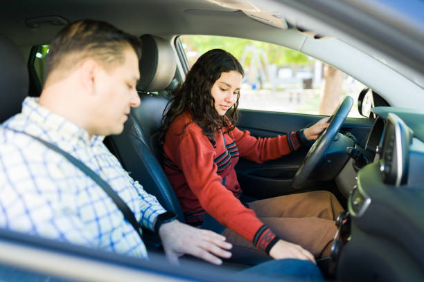 istock Hispanic teen practicing driving with her father by her side, focused on mastering driving skills 2184649007