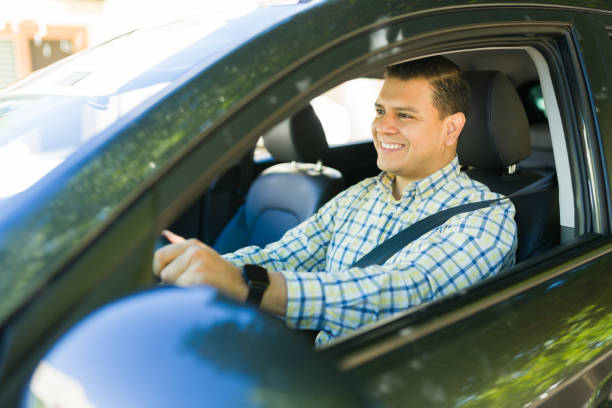 istock Happy hispanic man wearing a seatbelt while driving to work in his car 2184653441