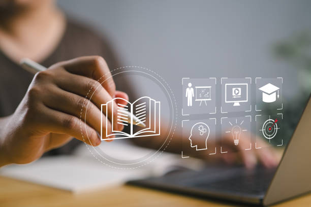 istock E-learning education concept. Person use laptop with virtual screen of online e-learning icons for increase business working skills. learning online with webinar, video tutorial, internet lessons 2184657728
