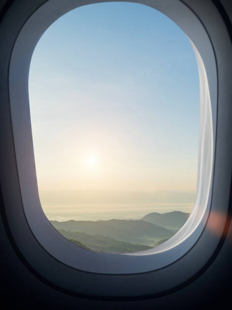 istock airplane window and mountain view with sunset sky background 2184662365