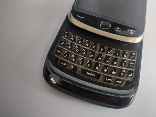 Old black cell phone, keyboard slide on white background