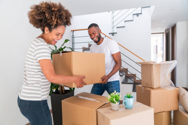 Loving couple moving house together and packing in boxes stock photo