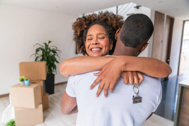istock Couple hugging while celebrating buying a house and holding the keys 2184665133