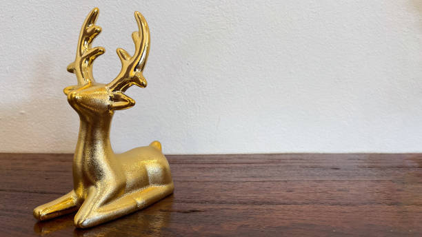 istock Golden deer statue on wooden background 2184680196