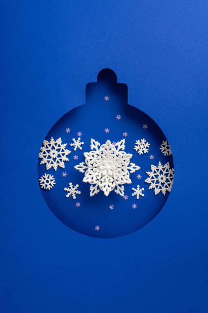 Abstract vertical design featuring intricate snowflakes and a bauble shape against a vibrant blue background, perfect for Christmas and winter themes