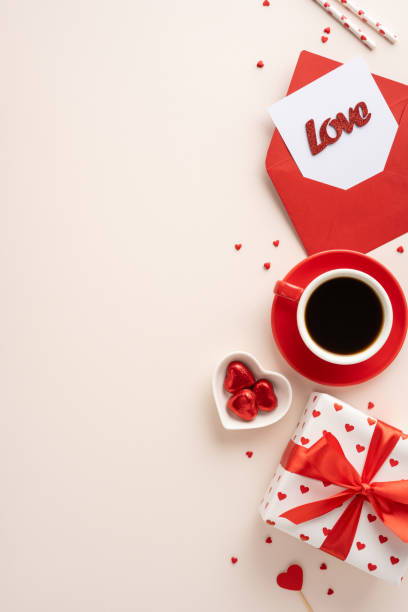 istock Top vertical view of a romantic Valentine's Day theme with coffee, red heart-shaped chocolates, gifts, and an envelope with a love card 2184681119