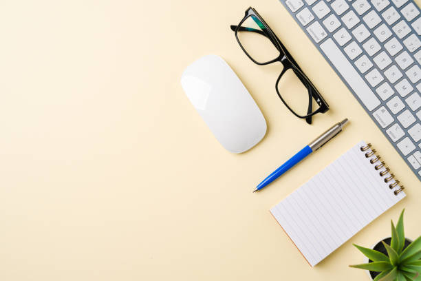 istock Office desk with computer keyboard, mouse, glasses, notebook and pen. Top view with copy space. Flat lay 2184682321