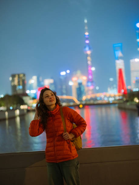 Woman looking at Shanghai cityscape at night during her trip in China