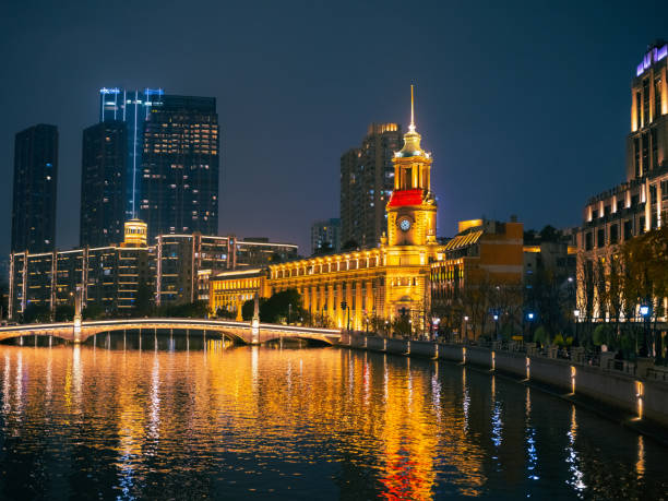 The Bund neighbourhood with its reflection in Hangpu river in Shanghai, China at night