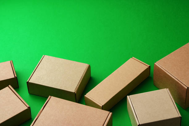 istock Brown cardboard boxes arranged on a vibrant green surface 2184688685