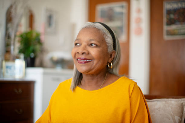 istock Senior African woman, thinking and home with smile on sofa for reflection, memory or relax in living room. Elderly person, inspiration and perspective with insight, happy or morning on couch in house 2184691687