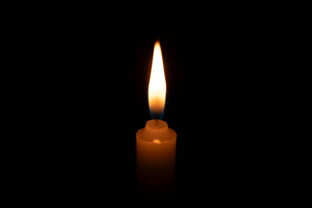 istock A candle flame glowing against a dark background 2184692884