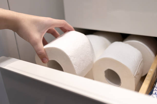 istock Taking Toilet Paper Roll from Modern Bathroom Storage Drawer, Hand Reaching for White Tissue Roll in Organized Cabinet Space for Essential Home Supplies Management 2184693445