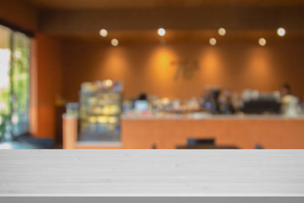 Abstract blur interior coffee shop restaurant or cafe and kitchen for background, counter top on of clean abstract home indoor. Warm tone used for display or montage your food dining banner products.