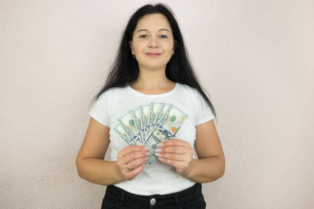 istock A woman holds dollars in her hands. 2184695097