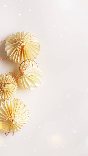 istock New Year decorative ornaments, golden Christmas flashlights shape bauble on light background, Minimal layout of paper festive decor beige balls, modern decor, top view, light effects, phone format 2184695687