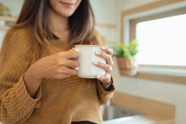 istock Beautiful millennial woman enjoying a warm drink in a bright kitchen 2184696401