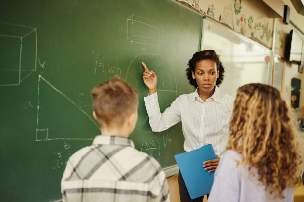 istock African American teacher explaining geometry to schoolkids during a class at elementary school. 2184696993
