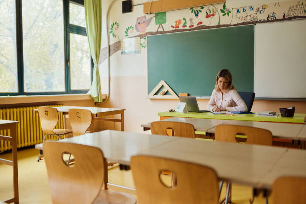 istock Female teacher grading exams in the classroom. 2184697097