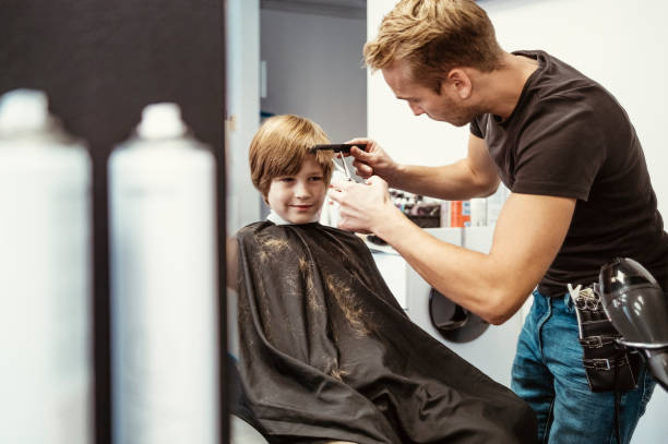 istock Young Boy Getting Haircut at Stylish Salon 2184697889