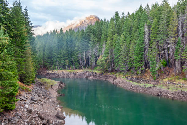 istock Mountain peak over the green water river in forest 2184698699