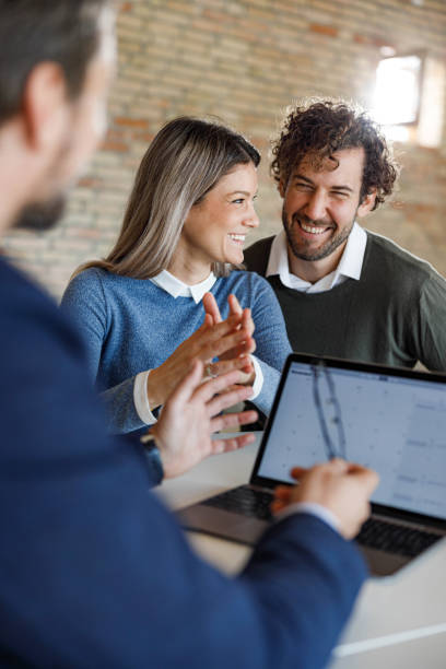 istock Cheerful couple talking to their agent in the office. 2184699758