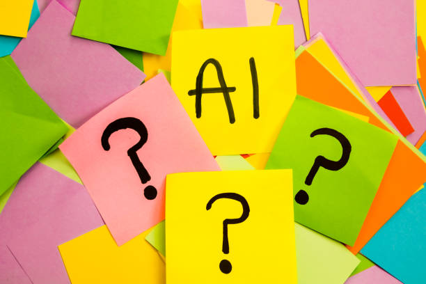 Yellow sticky note paper with written letter AI, on colored papers with question marks