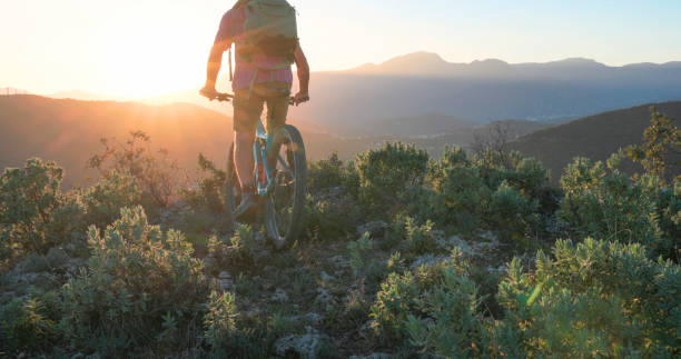 istock Mature mountain biker rides hills at sunrise 2184701658