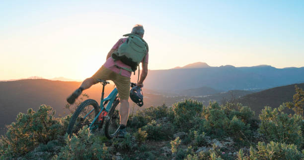 istock Mature mountain biker rides hills at sunrise 2184701659