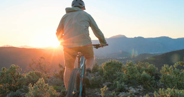 istock Mature mountain biker rides hills at sunrise 2184701663