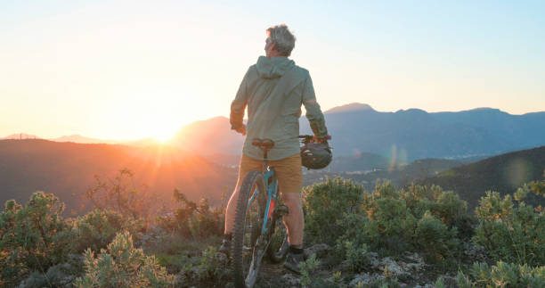istock Mature mountain biker rides hills at sunrise 2184701676
