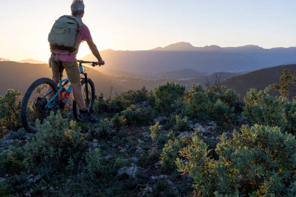 istock Mature mountain biker rides hills at sunrise 2184701683