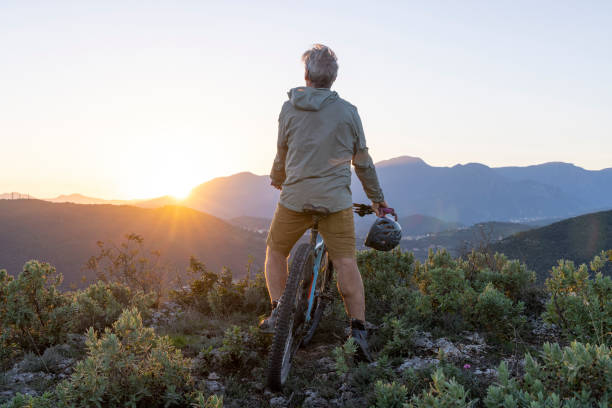 istock Mature mountain biker rides hills at sunrise 2184701719