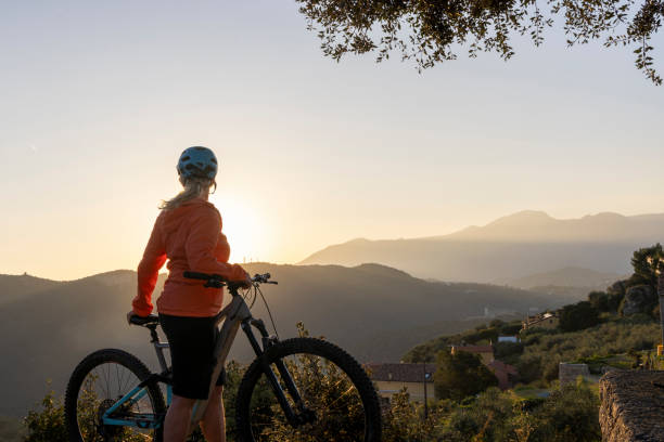 GIRL ON THE TOP OF A MOUNTAIN WITH HELMET AND GLOVES ON A MOUNTAIN BIKE