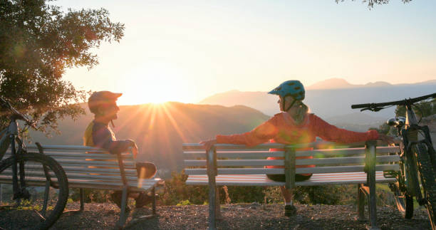 istock Mature couple watch sunrise over hills from bench 2184701818