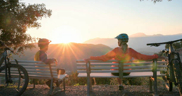 istock Mature couple watch sunrise over hills from bench 2184701820