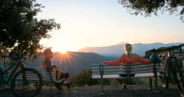 istock Mature couple watch sunrise over hills from bench 2184701829