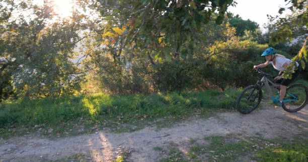 istock Mature woman rides e-bicycle through olive orchard 2184701848
