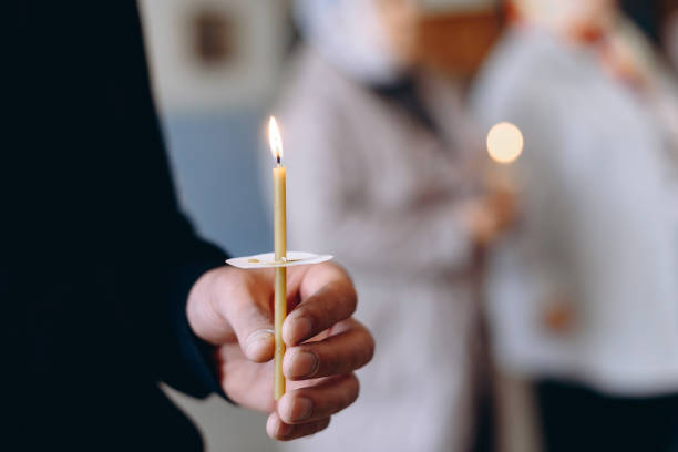 istock hand with church candle 2184703329