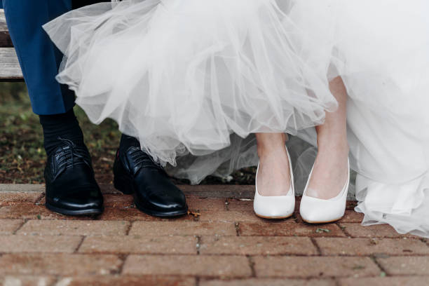 istock bride and groom sit on bench in park 2184706227