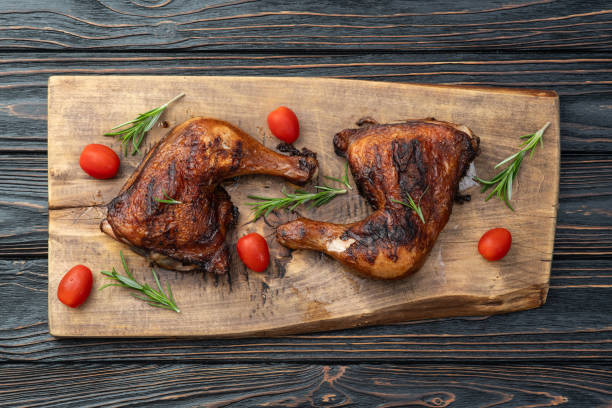 istock Grilled chicken legs with tomatoes and salad . Top view 2184711730