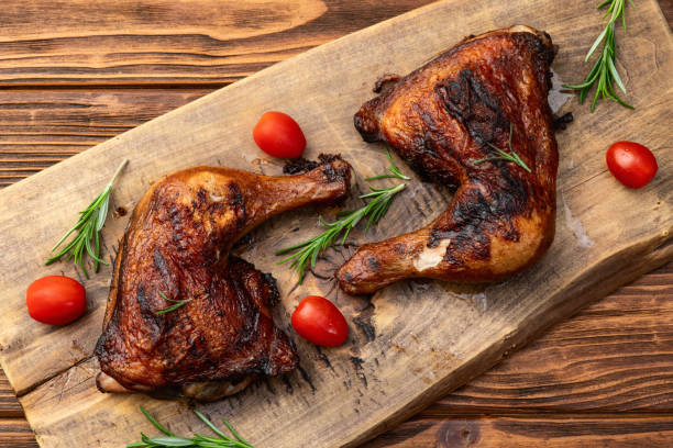 istock Grilled chicken legs with tomatoes and salad . Top view 2184711733